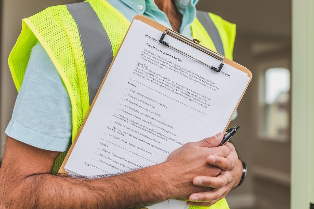 A man in a safety vest holding notes in his hands.